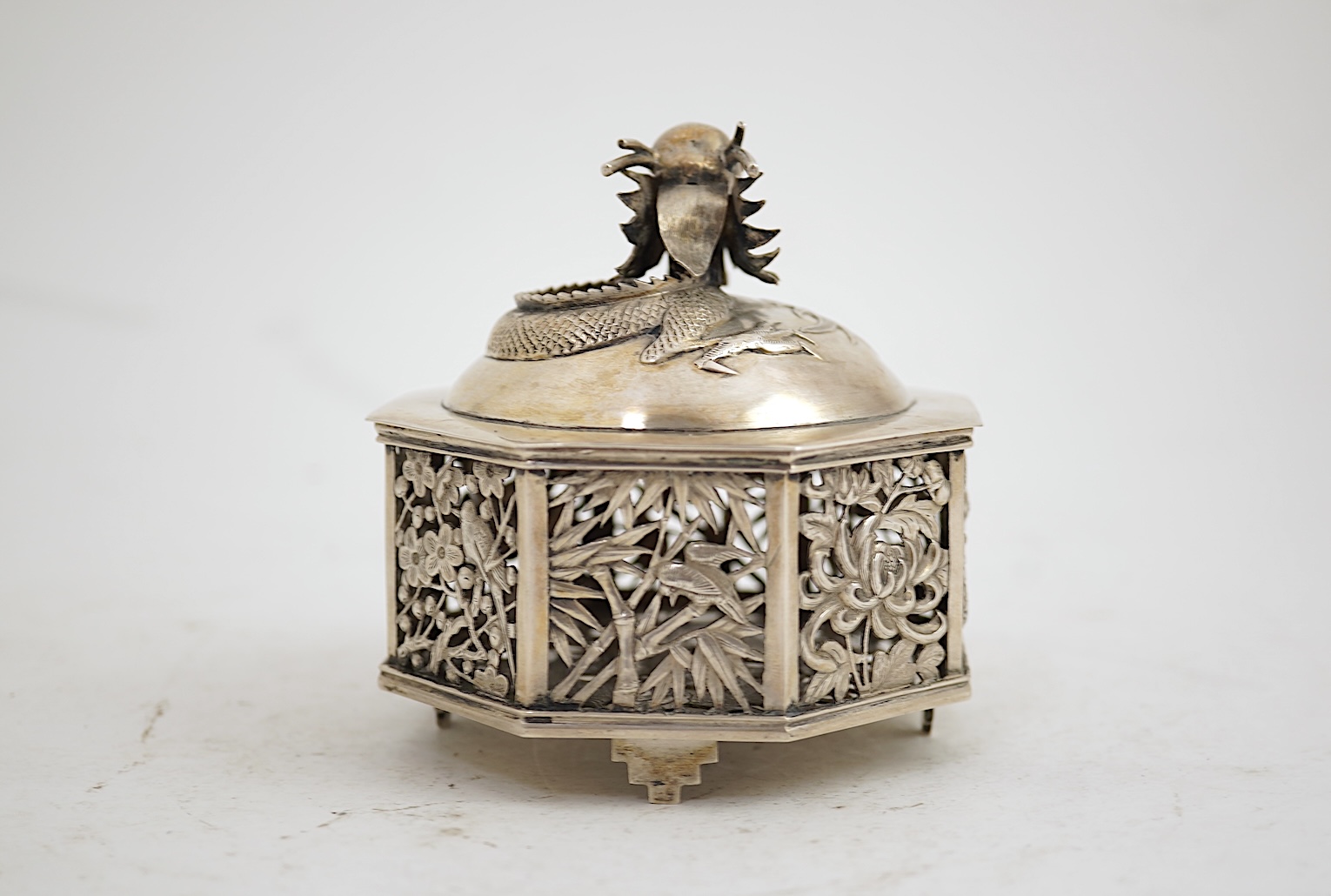 A late 19th century Chinese Export pierced silver card case, maker KMS(Kwong Man Shing), decorated with dragons amid clouds, 10.4cm, together with a Chinese Export pierced silver octagonal box and cover, by Luen Wo?, cir